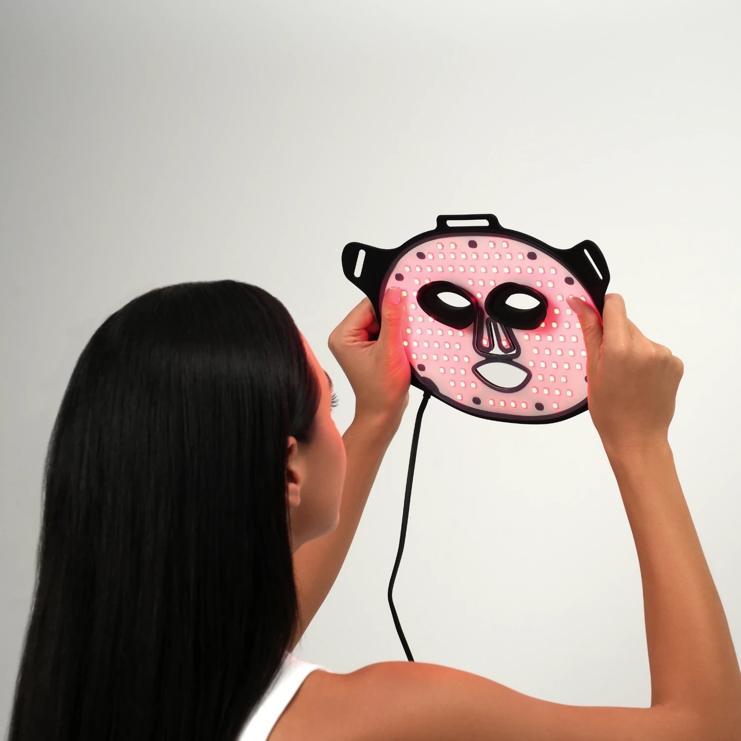 Person holding a Rayderma LED Wonder mask against a light grey background